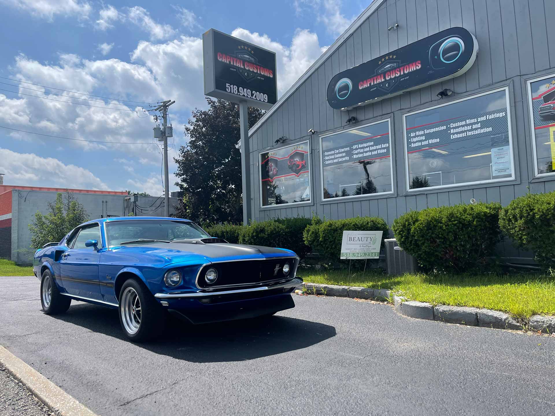 Exterior of the Capital Customs shop with a classic blue car