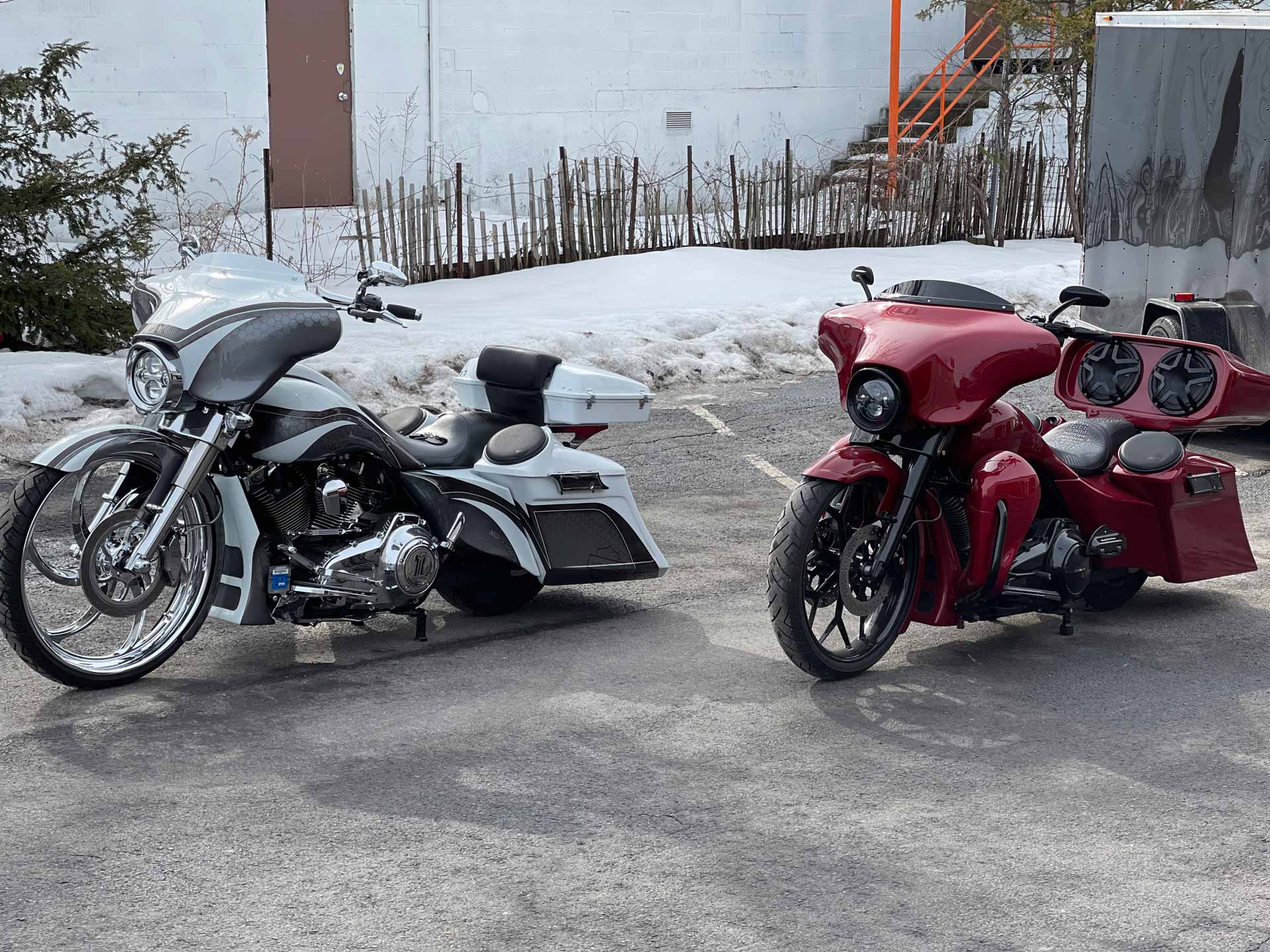 A red and a white motorcyle in a parking lot