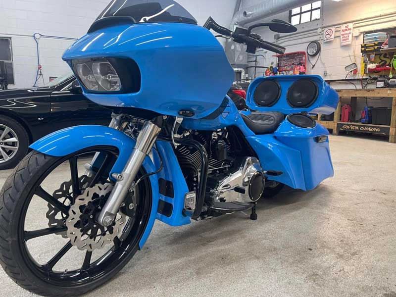 A bright blue motorcycle with a custom sound system